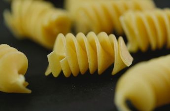 A close-up view of uncooked pasta noodles, showcasing various shapes and textures.