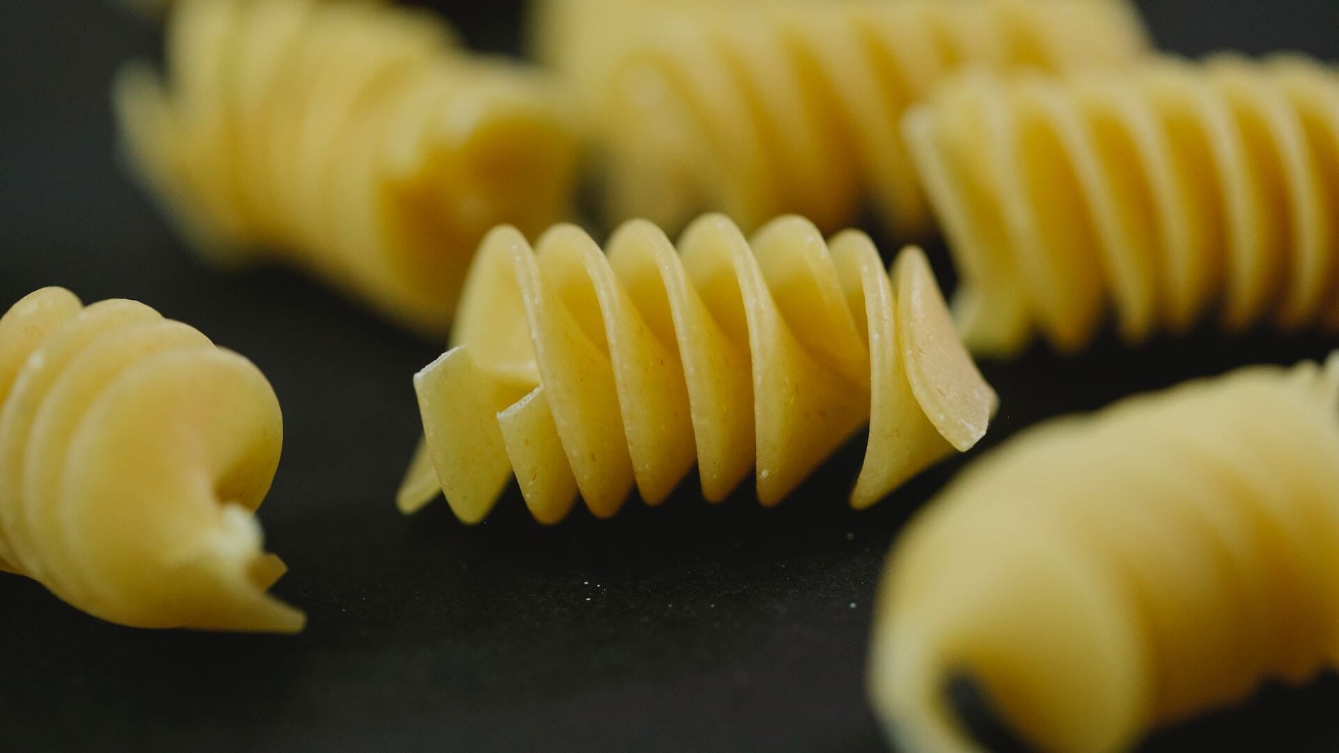 A close-up view of uncooked pasta noodles, showcasing various shapes and textures.